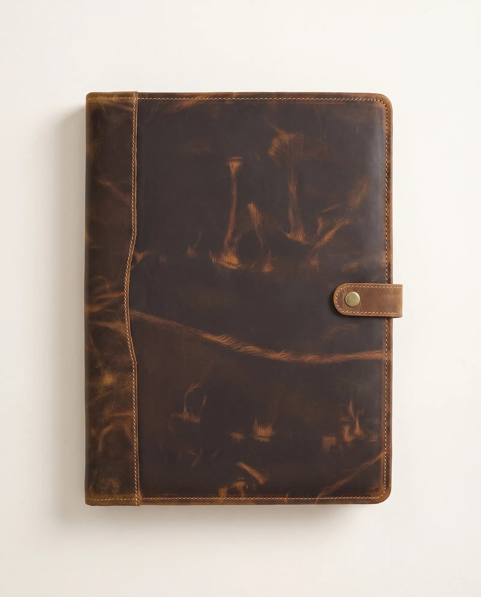 The antique brown buttoned leather portfolio, closed, seen from above